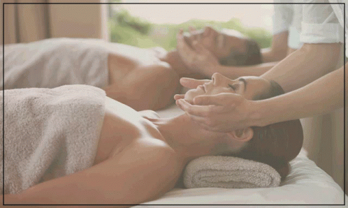 A Man And A Woman Are Laying On A Bed Getting A Massage GIF