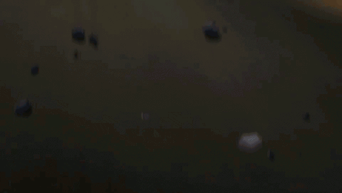 A Man And A Woman Are Laying On The Ground With A Fire Behind Them GIF