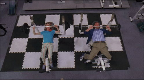 A Man And A Woman Are Lifting Weights On A Checkered Floor GIF