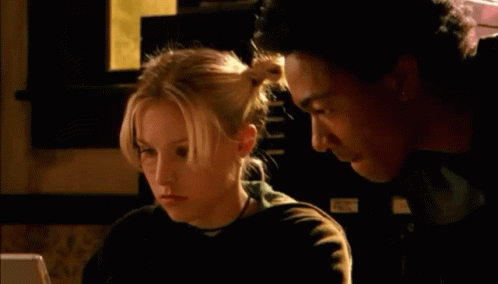 A Man And A Woman Are Looking At A Computer Screen And The Woman Is Saying " Ruh Roh " GIF