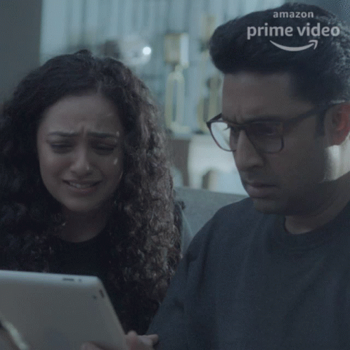 A Man And A Woman Are Looking At A Tablet With An Amazon Prime Video Logo In The Background GIF
