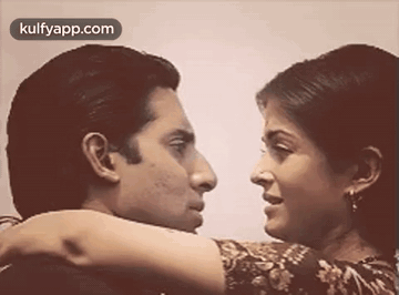 A Man And A Woman Are Looking At Each Other . GIF