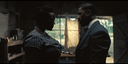 A Man And A Woman Are Looking At Each Other GIF