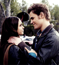 A Man And A Woman Are Looking At Each Other And Smiling GIF