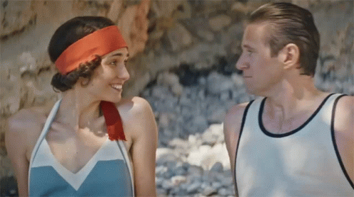 A Man And A Woman Are Looking At Each Other And The Woman Has A Red Headband On GIF
