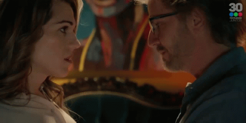 A Man And A Woman Are Looking At Each Other And The Woman Is Saying Contestame GIF