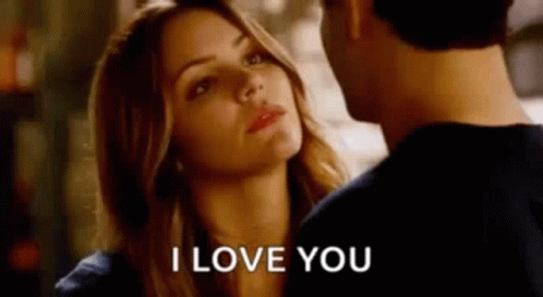 A Man And A Woman Are Looking At Each Other And The Woman Is Saying I Love You . GIF