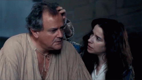 A Man And A Woman Are Looking At Each Other And The Woman Is Touching The Man 'S Forehead GIF