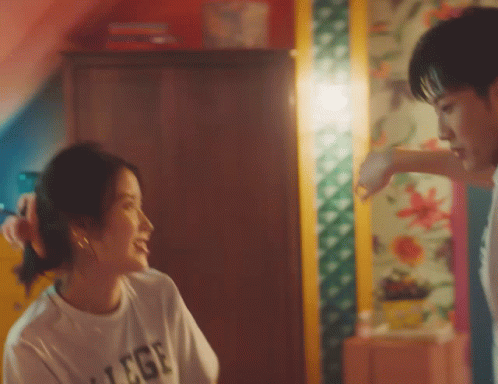 a man and a woman are looking at each other and the woman is wearing a t-shirt that says college