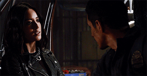 A Man And A Woman Are Looking At Each Other In A Car . The Woman Is Wearing A Leather Jacket . GIF