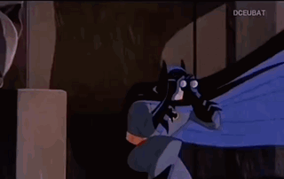 A Man And A Woman Are Looking At Each Other In A Dark Room . GIF