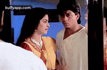 A Man And A Woman Are Looking At Each Other In A Room . GIF