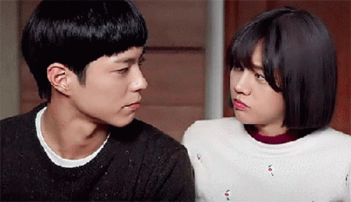 A Man And A Woman Are Looking At Each Other In A Room . GIF