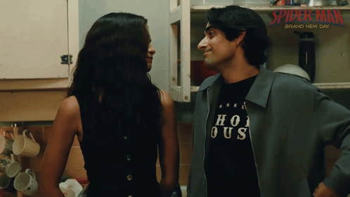 a man and a woman are looking at each other in front of a sign that says spider-man brand new day