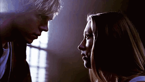 A Man And A Woman Are Looking At Each Other . GIF