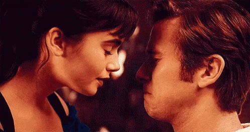 A Man And A Woman Are Looking At Each Other 'S Faces . GIF
