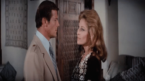 A Man And A Woman Are Looking At Each Other GIF