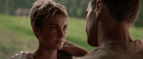 A Man And A Woman Are Looking At Each Other . The Woman Has Short Hair . GIF