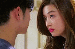 A Man And A Woman Are Looking At Each Other . The Woman Is Wearing Pink Lipstick . GIF