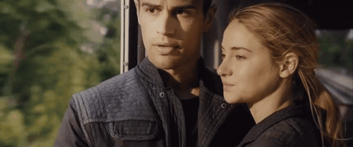 A Man And A Woman Are Looking At Each Other While Sitting Next To Each Other On A Bus . GIF