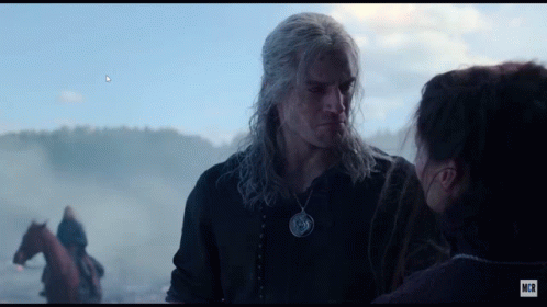 A Man And A Woman Are Looking At Each Other With A Horse In The Background GIF