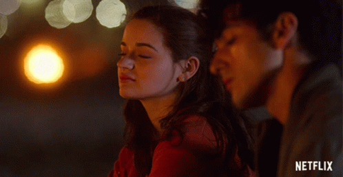 A Man And A Woman Are Looking At Each Other With A Netflix Logo In The Background GIF