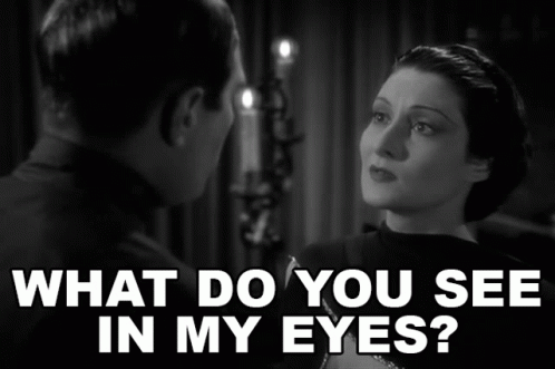 A Man And A Woman Are Looking At Each Other With The Words What Do You See In My Eyes Above Them GIF