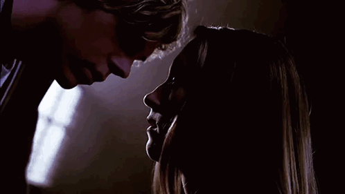 A Man And A Woman Are Looking Into Each Other 'S Eyes In The Dark . GIF