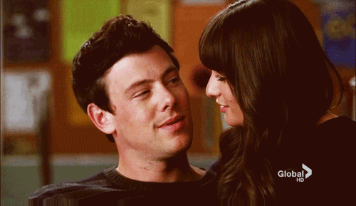 A Man And A Woman Are Looking Into Each Other 'S Eyes With A Global Hd Advertisement In The Background GIF