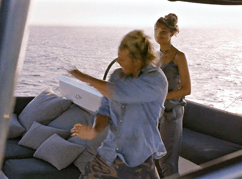 A Man And A Woman Are On A Boat With A Box That Says ' A ' On The Side GIF