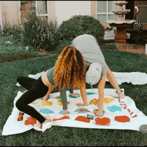 A Man And A Woman Are Playing A Game Of Twister Outside GIF