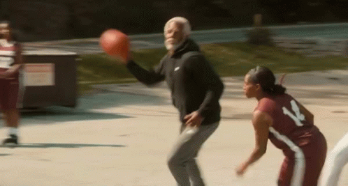 a man and a woman are playing basketball on a court and the man is throwing the ball to the woman .