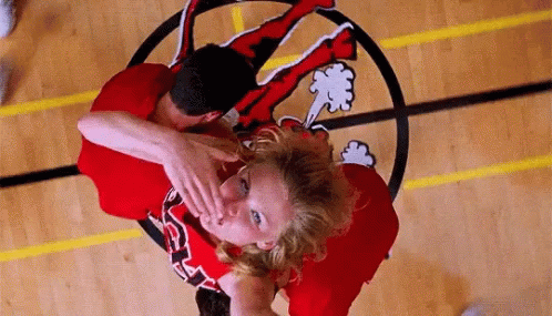 A Man And A Woman Are Playing Basketball On A Court With A Logo On The Floor . GIF