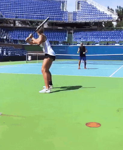 A Man And A Woman Are Playing Tennis On A Tennis Court GIF