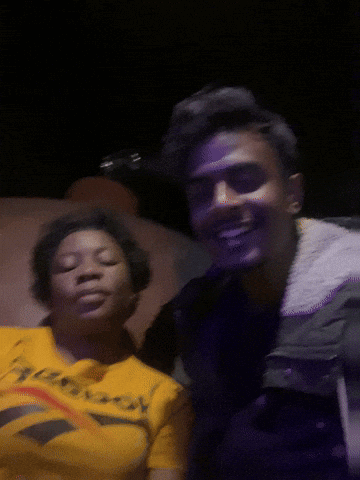 A Man And A Woman Are Posing For A Picture And The Woman Is Wearing A Reebok Shirt GIF