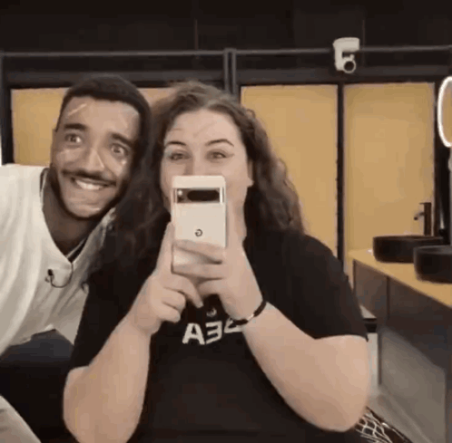 a man and a woman are posing for a picture and the woman is wearing a shirt that says a32 on it