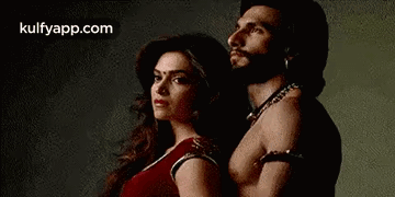 A Man And A Woman Are Posing For A Picture . GIF