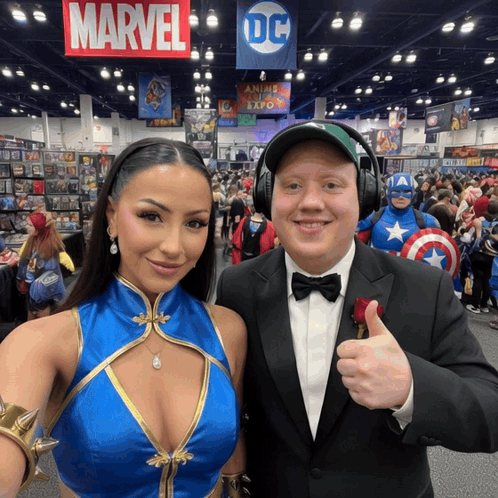 A Man And A Woman Are Posing For A Picture In Front Of A Sign That Says Marvel GIF