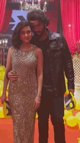A Man And A Woman Are Posing For A Picture In Front Of A Starring Sign GIF