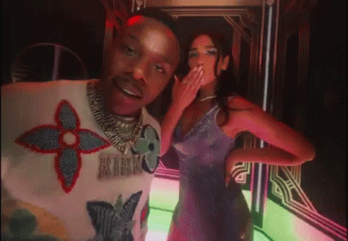 A Man And A Woman Are Posing For A Picture . The Woman Is Wearing A Purple Dress . GIF