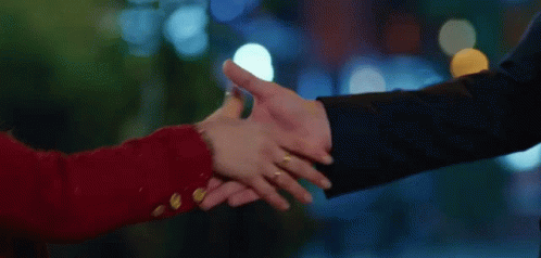 A Man And A Woman Are Shaking Hands And The Woman Has A Ring On Her Finger GIF