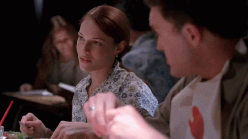a man and a woman are sitting at a table eating food