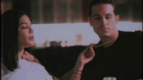 A Man And A Woman Are Sitting At A Table Eating Food With A Fork And Knife . GIF