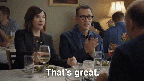 A Man And A Woman Are Sitting At A Table In A Restaurant Applauding And Saying That 'S Great GIF