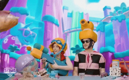 A Man And A Woman Are Sitting At A Table In Front Of A Colorful Background . GIF