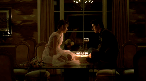 Man And Woman Sitting At Table With Cake GIF