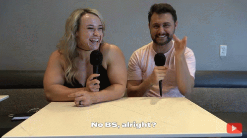 A Man And A Woman Are Sitting At A Table With Microphones And One Of Them Says No Bs Alright GIF