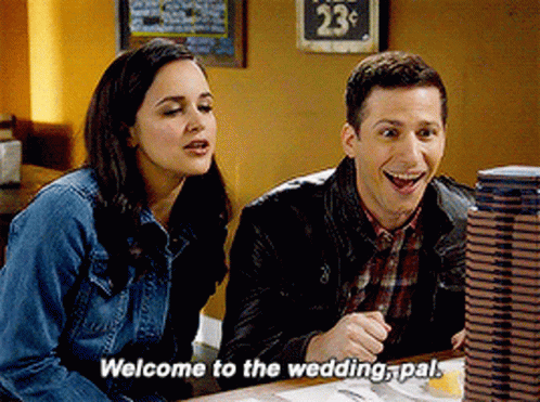 A Man And A Woman Are Sitting At A Table With The Man Saying Welcome To The Wedding Pal GIF