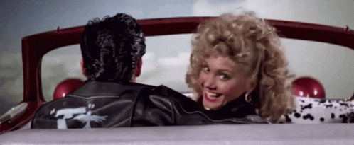 A Man And A Woman Are Sitting In A Car . GIF