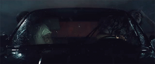 a man and a woman are sitting in a car that is covered in water